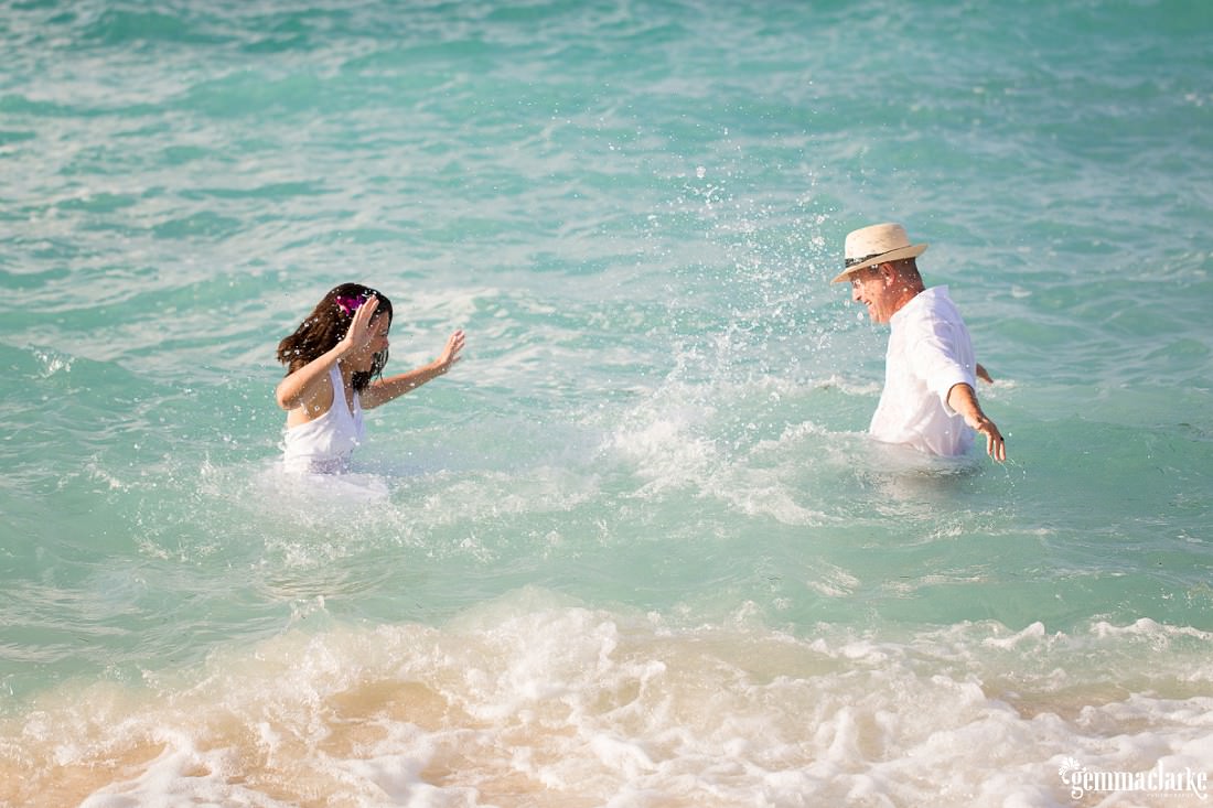 A bride and groom splashing around in the sea - Trash the Dress