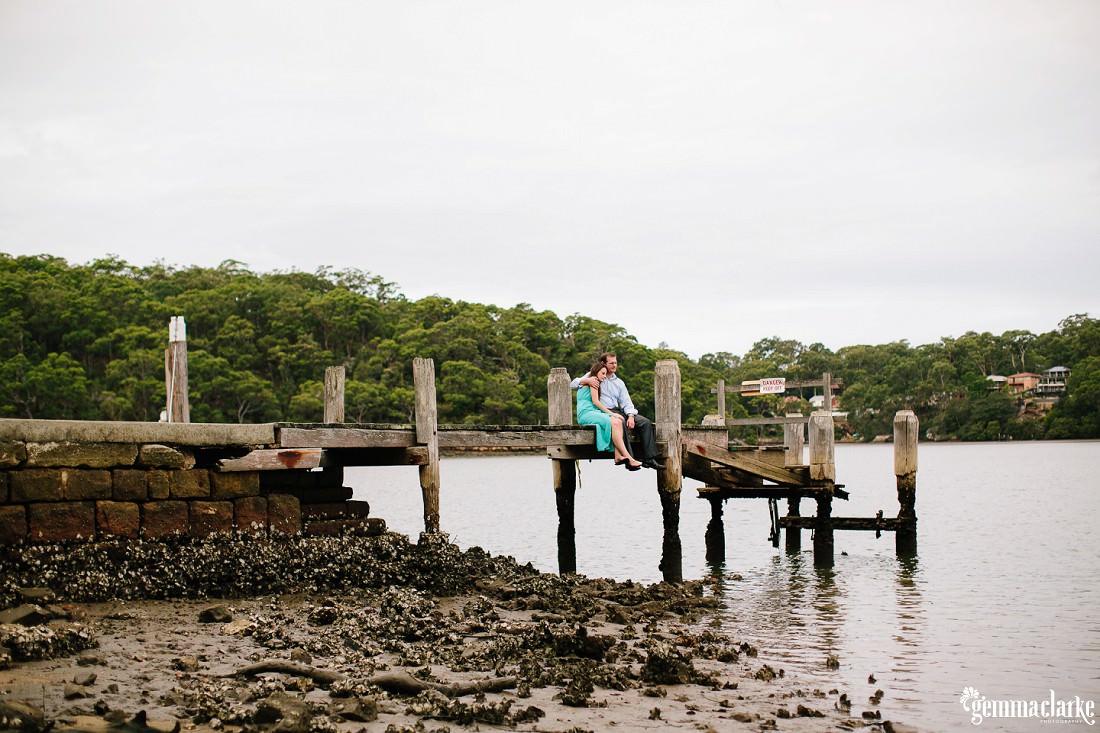A man and woman sitting together on a small wharf - Oatley Park Portraits