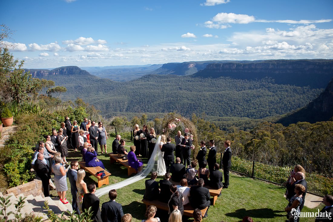 A stunning view of the ceremony with bridal party and guests and the Blue Mountains as the backdrop at this Echoes Hotel Wedding.