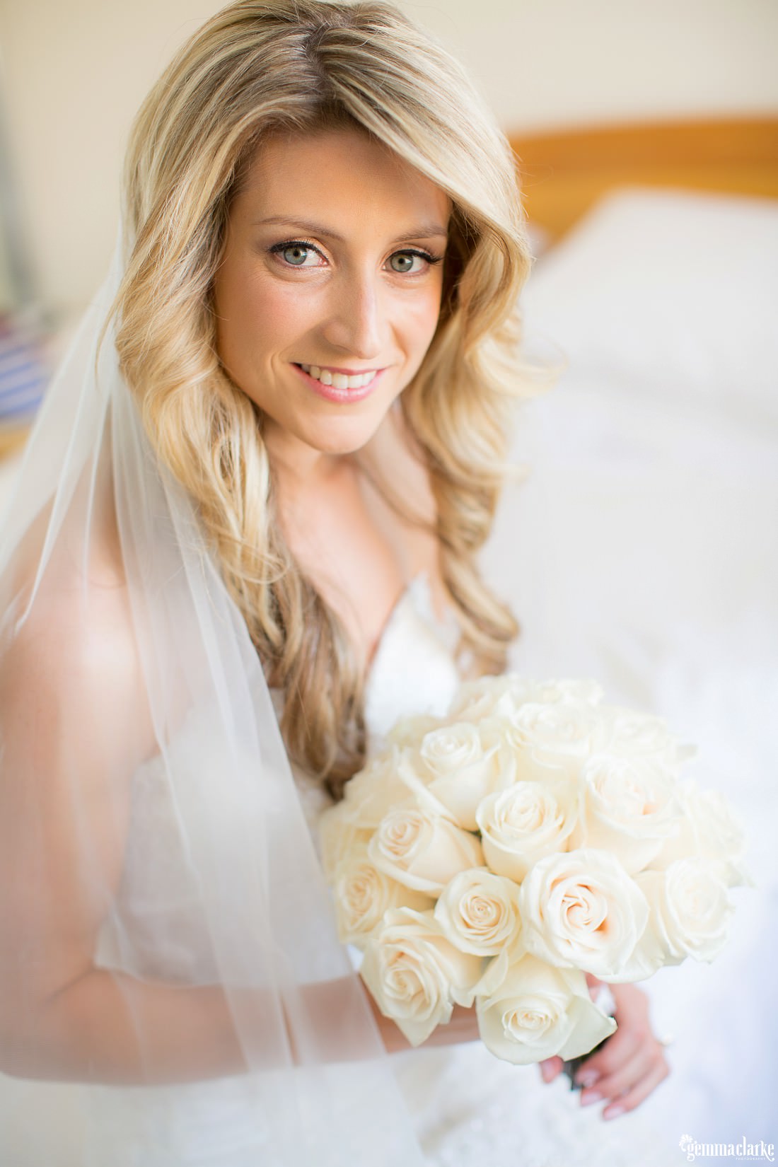 A smiling bride posing with her bouquet - Horizons Wedding