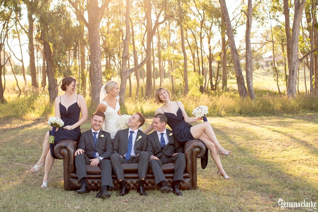 A bridal party relaxing on a leather couch in the outdoors - Twine Restaurant Wedding