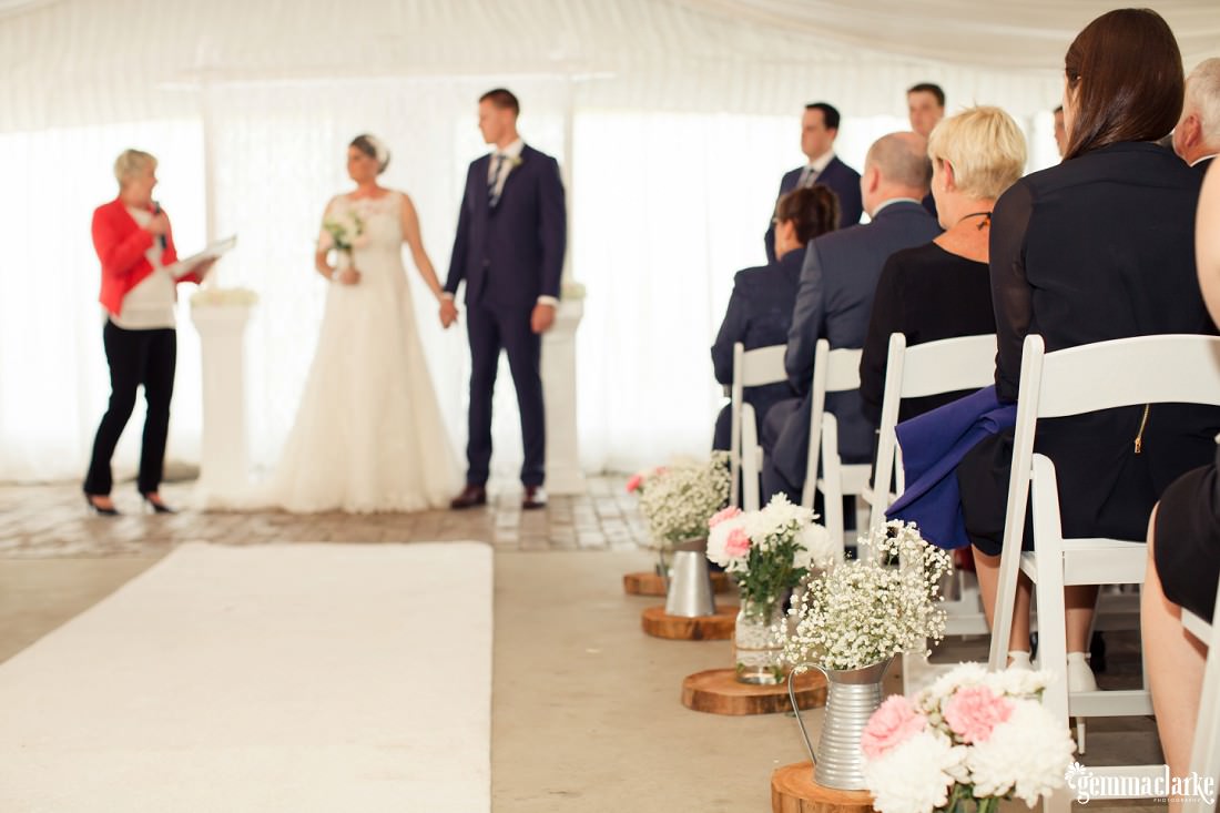 Flowers in steel milk jugs decorations at a wedding ceremony - Camden Wedding