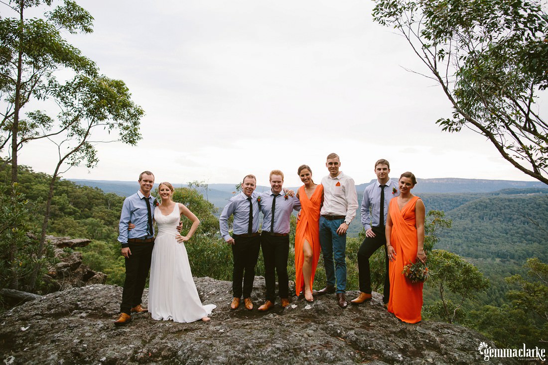 A bridal party standing on a rock overlooking a forest – Kangaroo Valley Bush Retreat