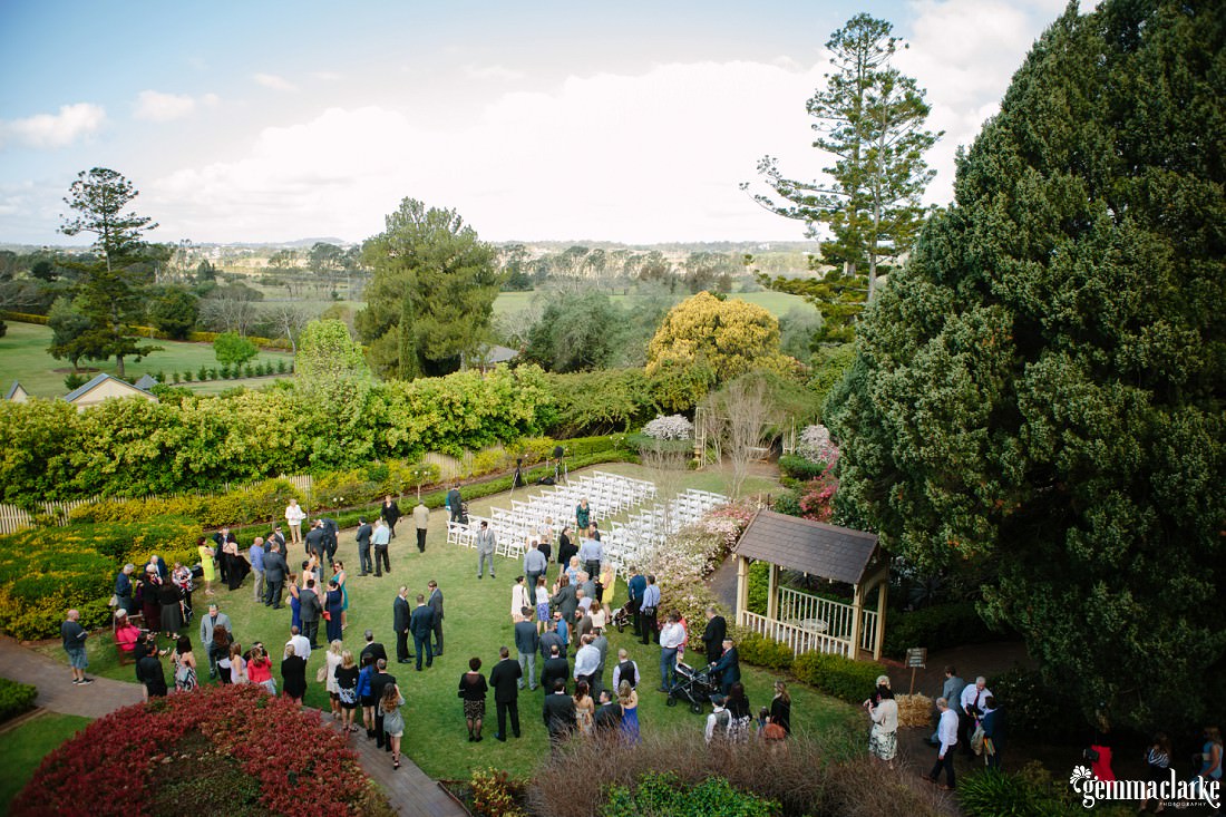 Wedding guests mingling in a garden before the ceremony begins