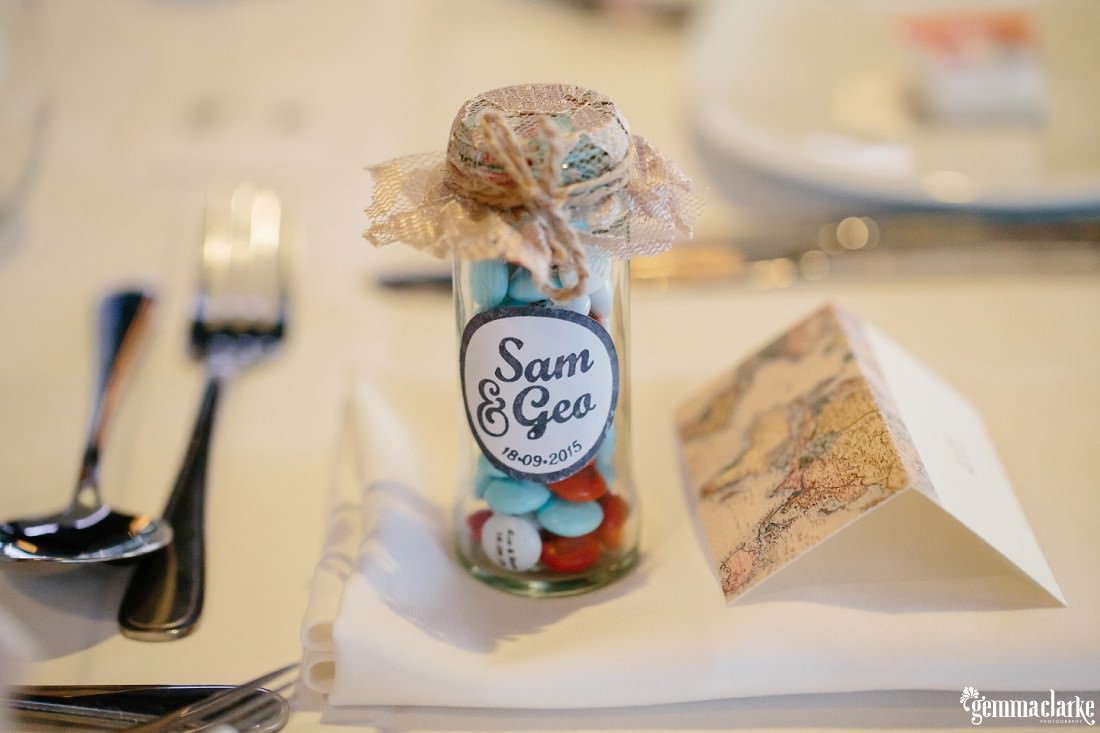 A small glass jar of lollies at a table setting