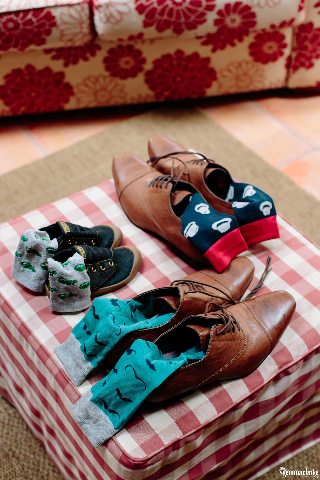 Two pairs of brown male adult shoes with socks and a small pair of young boys shoes and socks