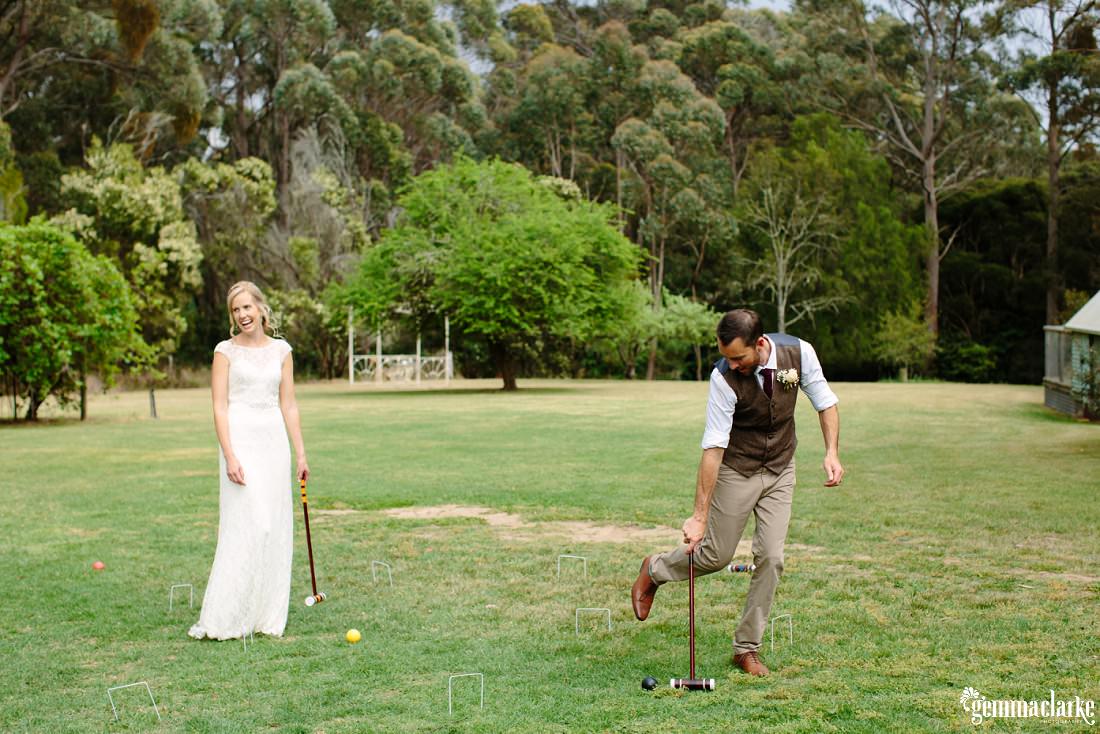 A bride and groom playing a game of croquet 