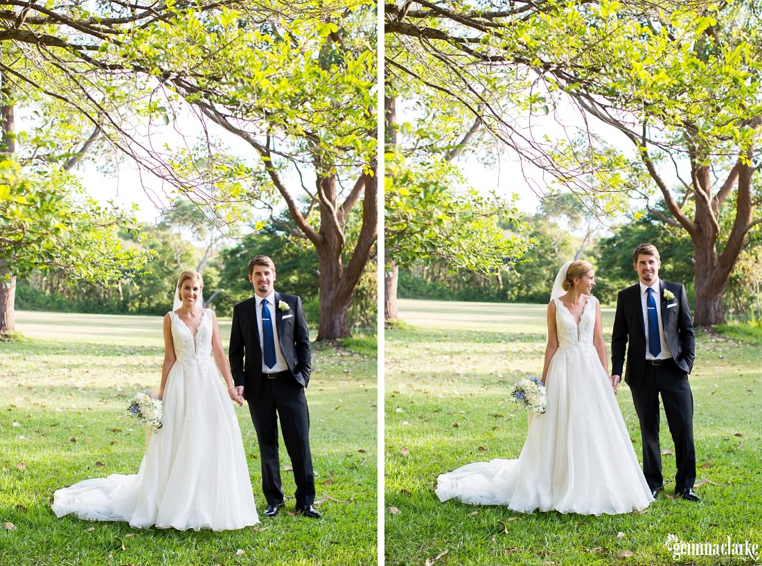 A smiling bride and groom holding hands underneath some trees