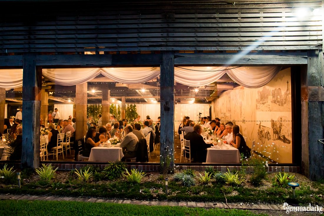 An outside shot of a wedding reception in a wooden building at night
