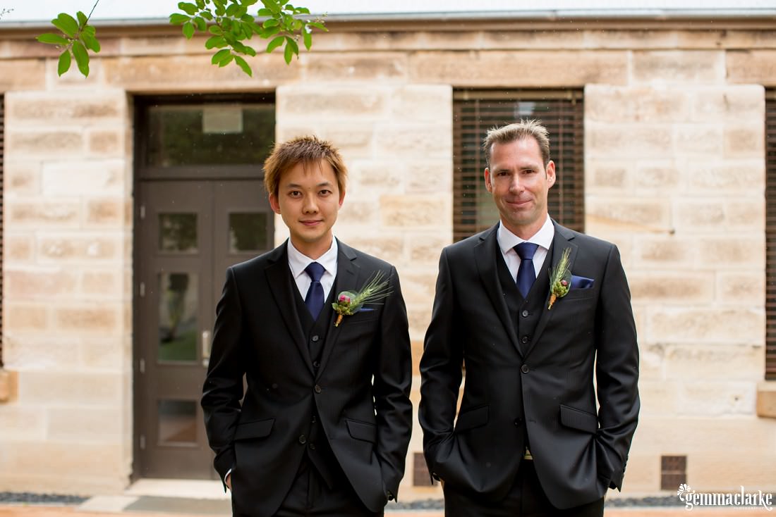Groomsmen smile and stand with hands in their pockets