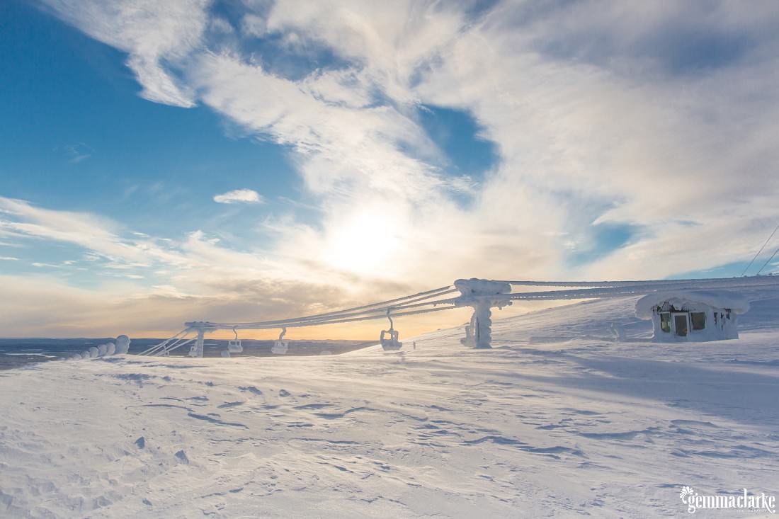 Sun shines through clouds over a ski field
