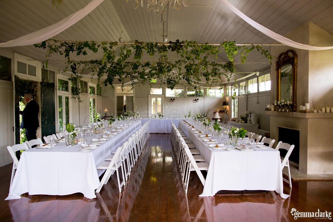 Summerlees wedding reception room with hanging vines and white tables