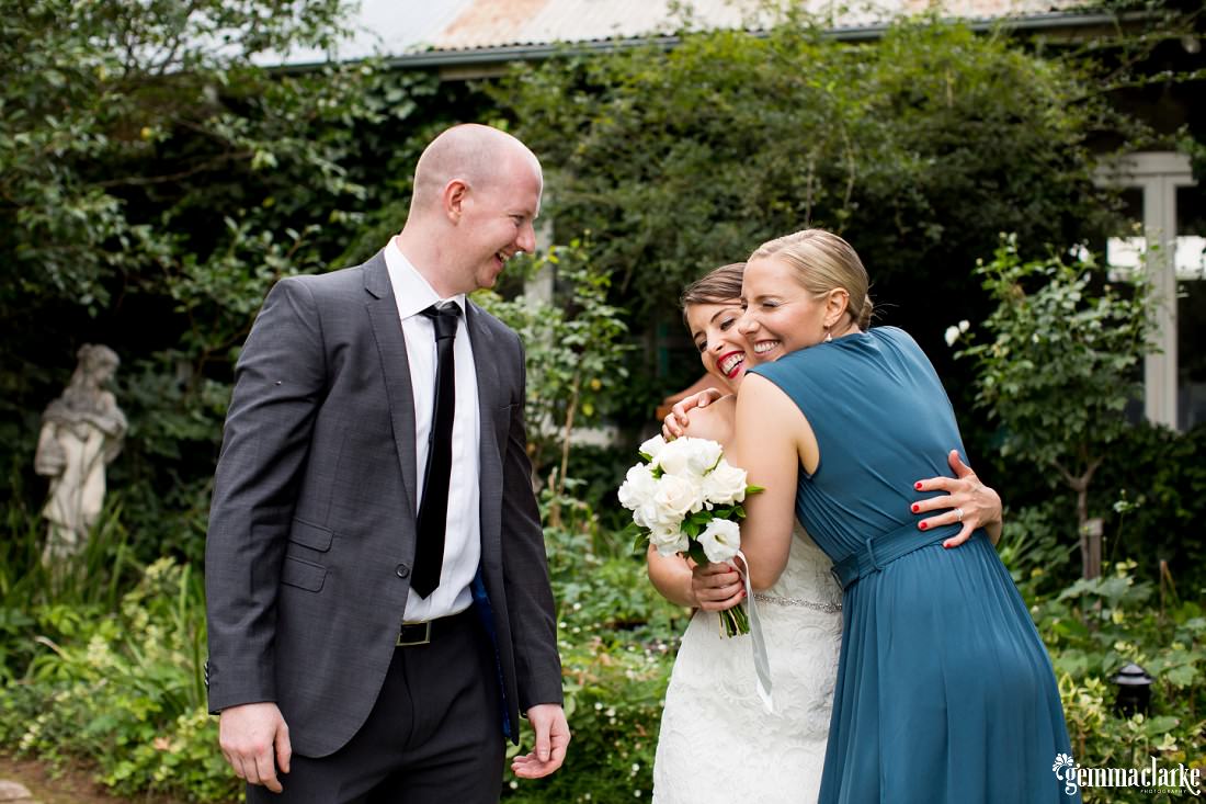A bride is hugged and congratulated by wedding guests