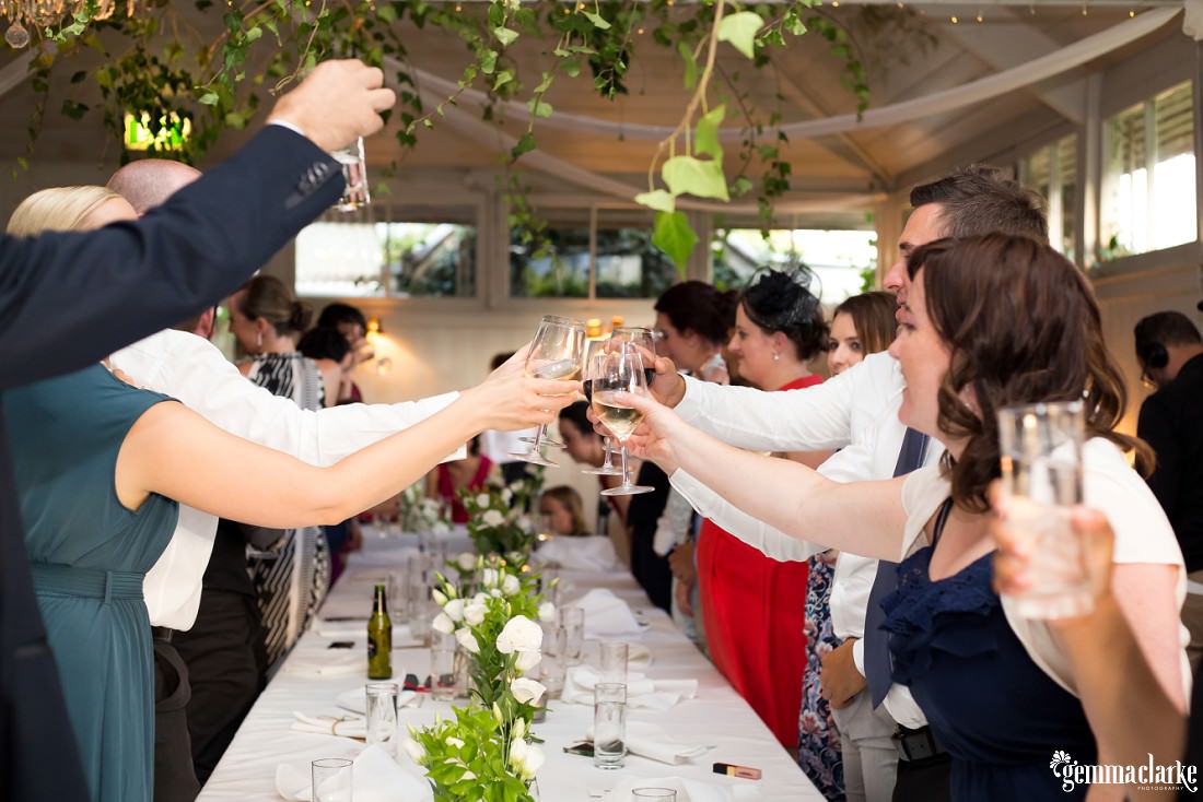 Wedding guests raise their glasses in celebration