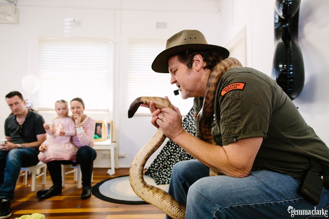Ranger Steve from Walkabout Reptiles is showing off a huge snake that is wrapped round his neck!