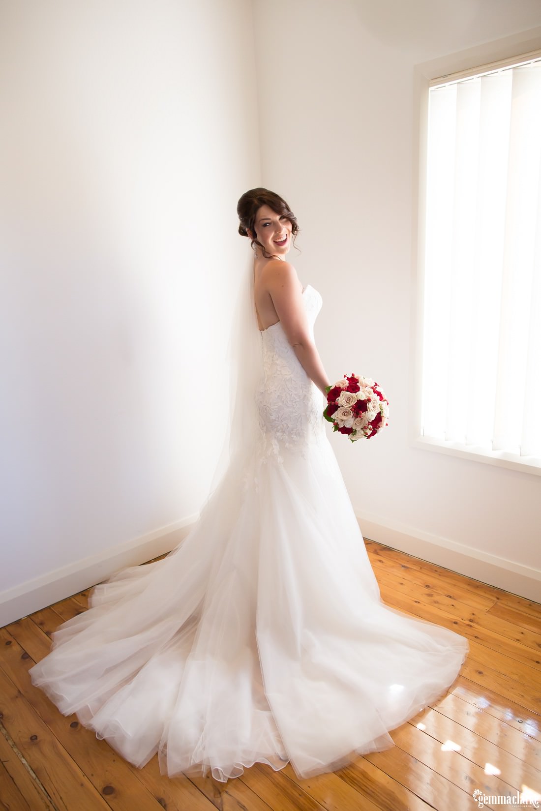 A bride posing and showing off her lovely flowing gown and bouquet - Deckhouse Wedding