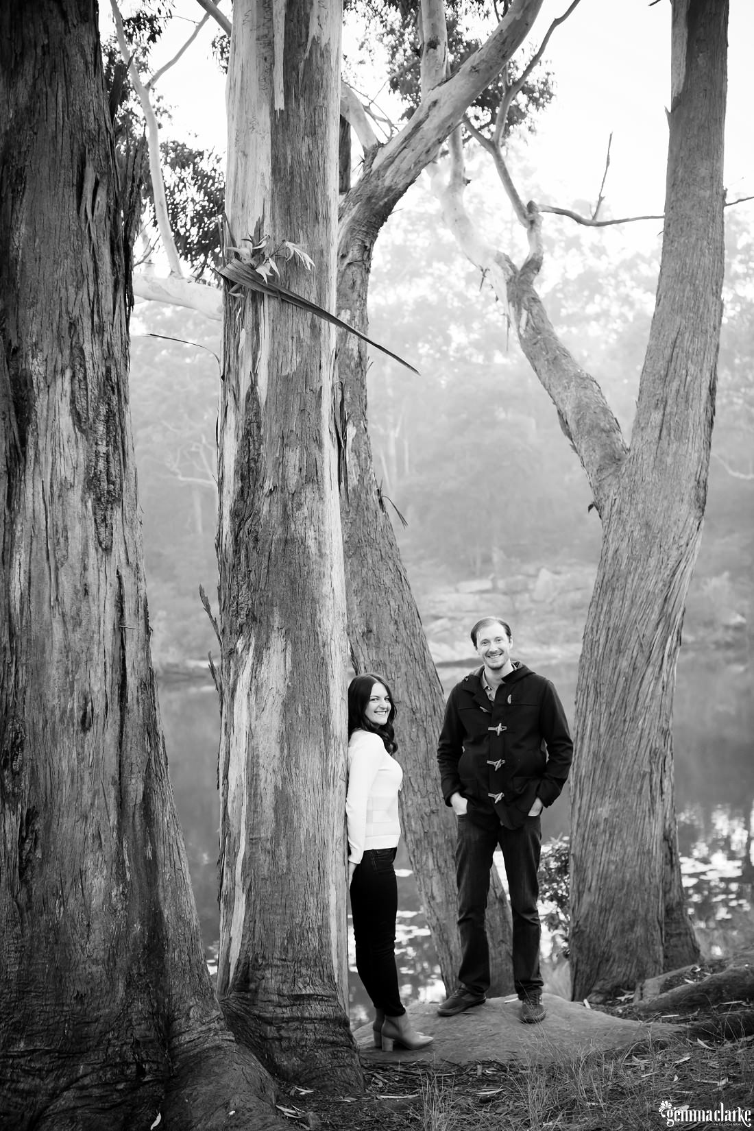 Black and white photo of the couple standing amongst the textured bark trees - Lake Parramatta