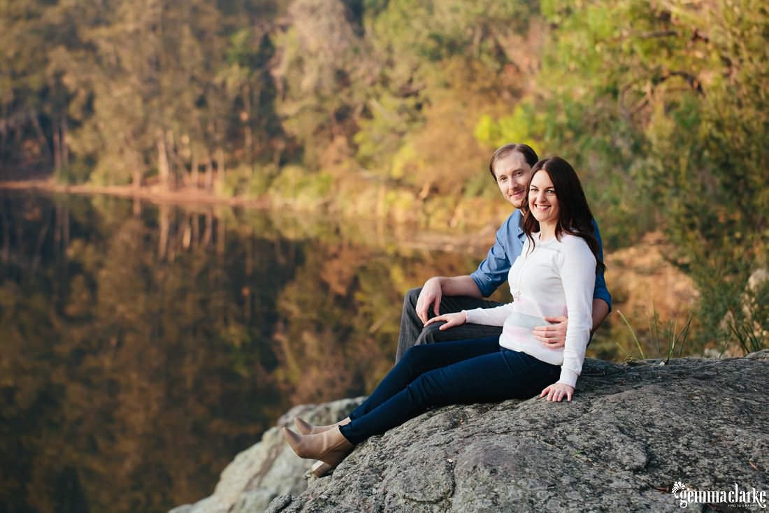 Couple smiling for the camera whilst sitting on a rock - Lake Parramatta