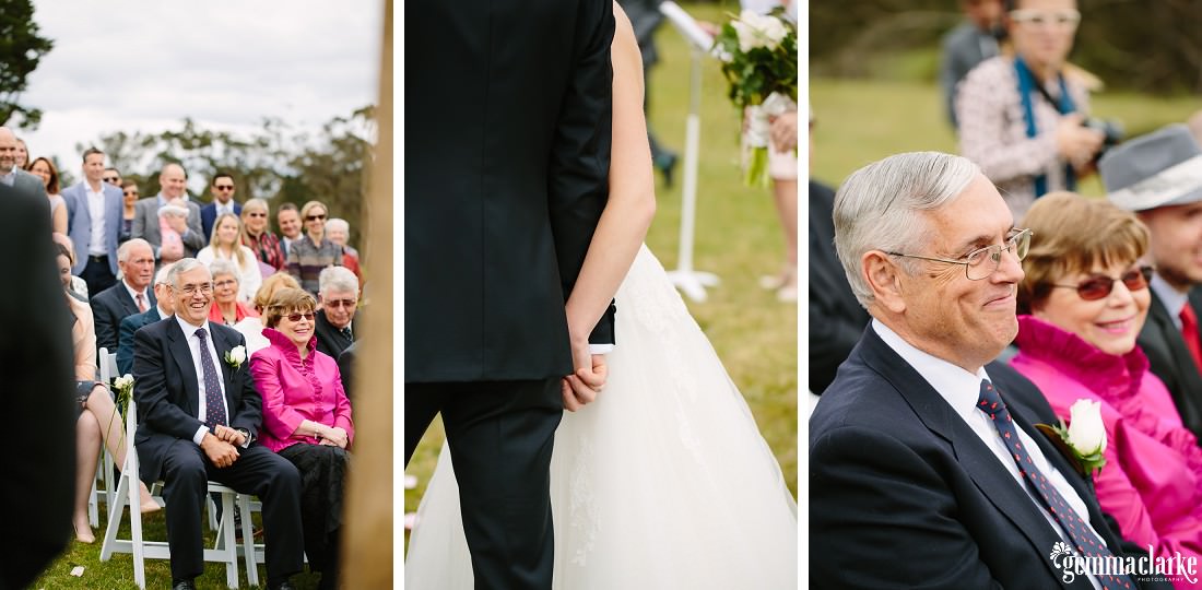 A bride and groom holding hands at their wedding ceremony as guests and relatives look on