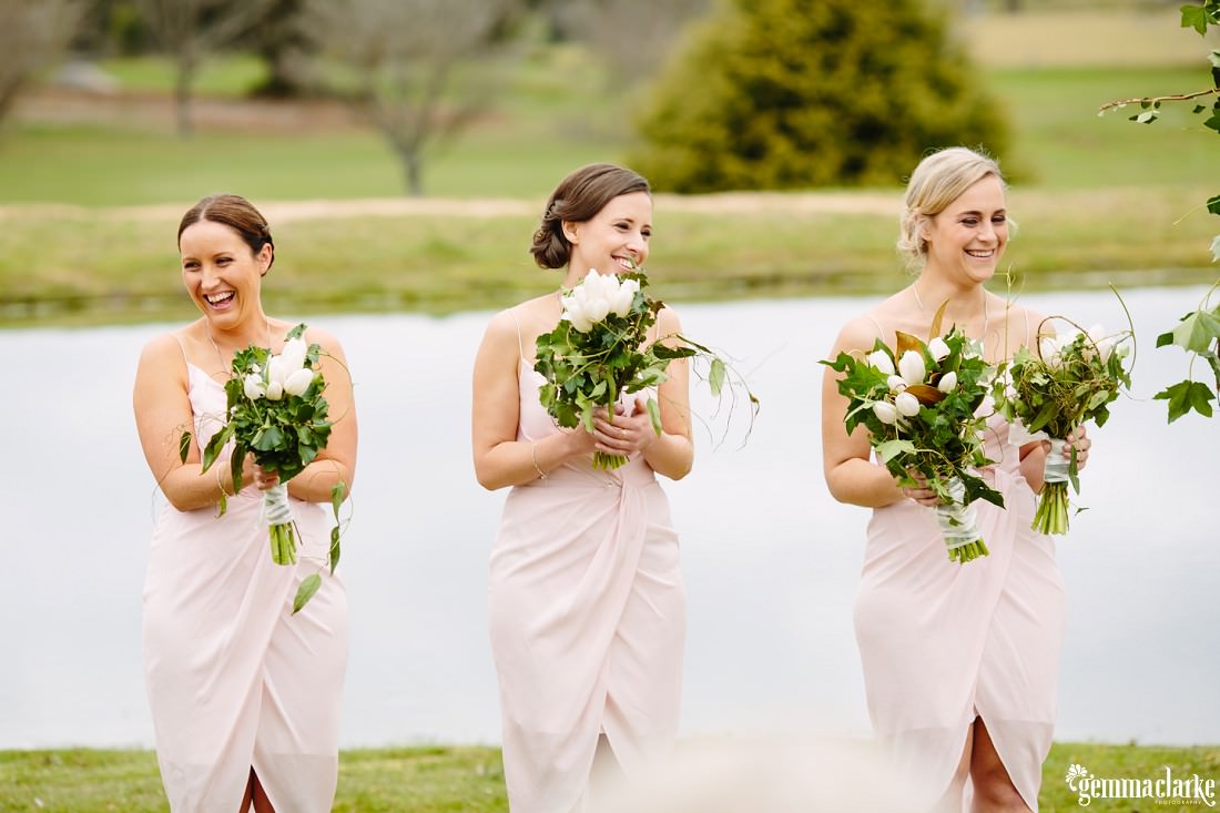 Three smiling bridesmaids at a wedding ceremony