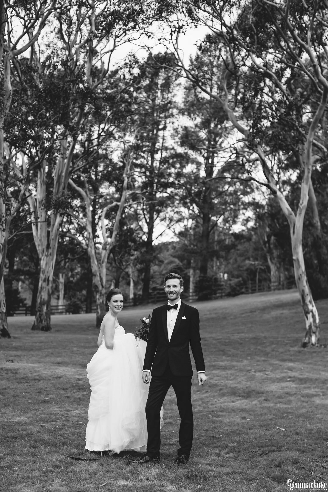 Black and white image of bride and groom standing without touching amongst the gum trees on the Golf Course at this Gibraltar Hotel Wedding