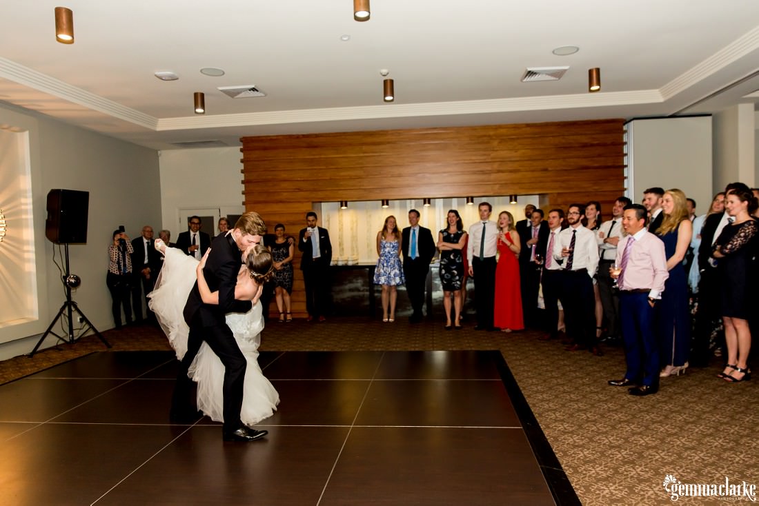A groom dips his bride during their first dance