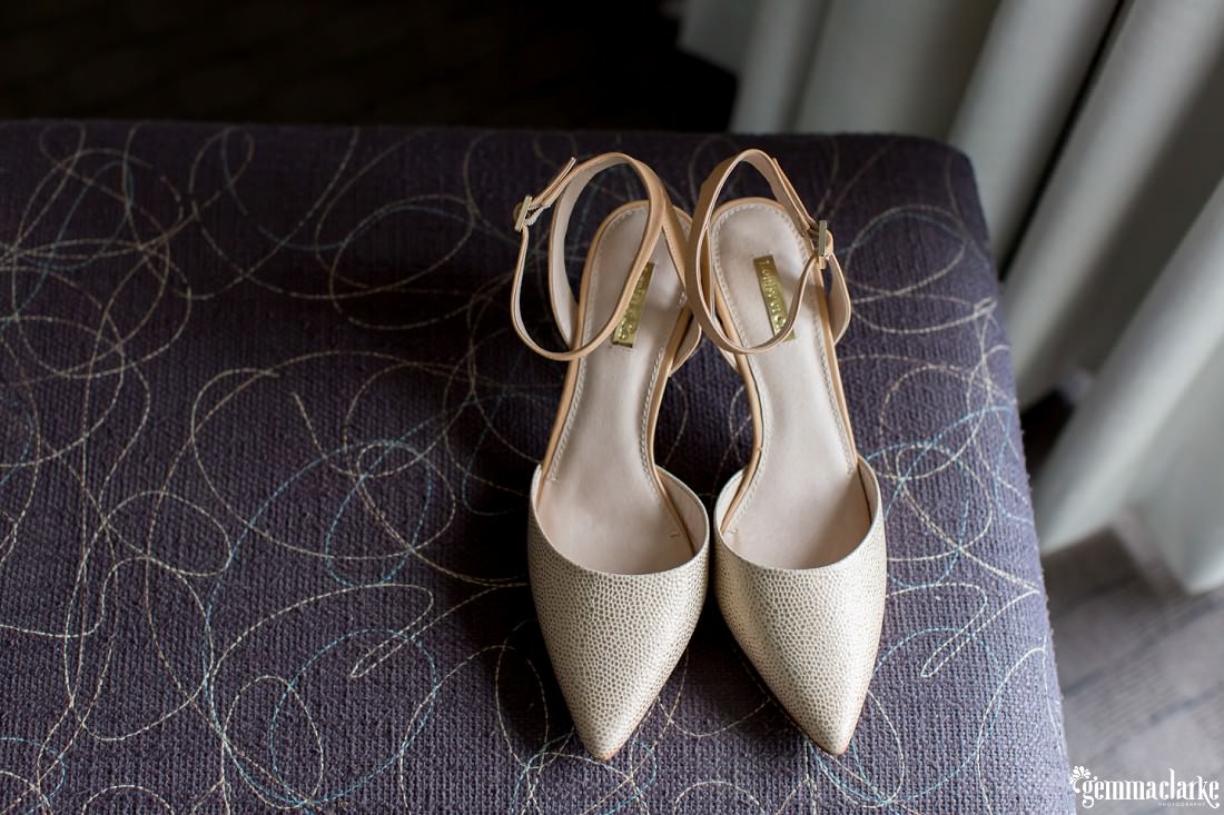 A bride's shoes on an ottoman