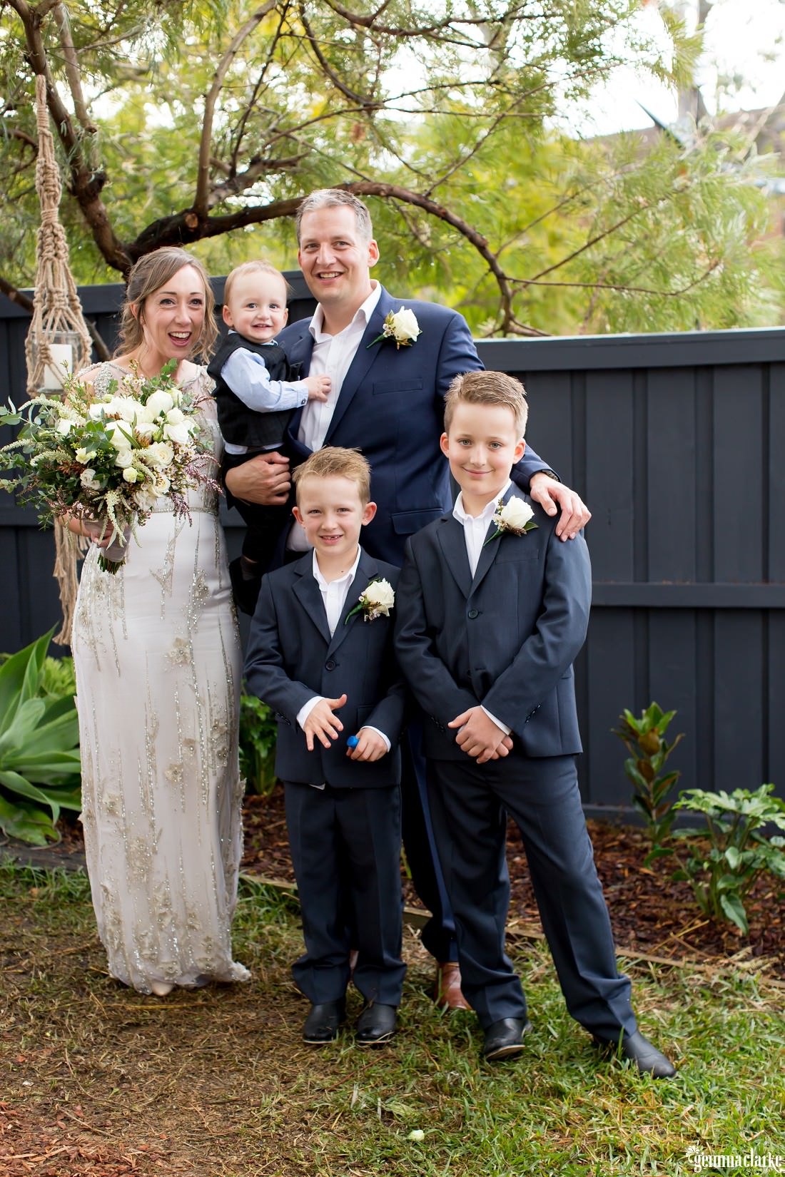 A bride and groom pose with their boys