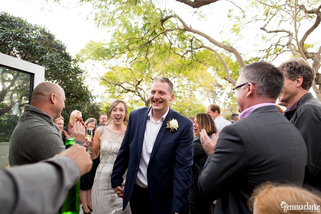 A bride and groom are congratulated by their wedding guests