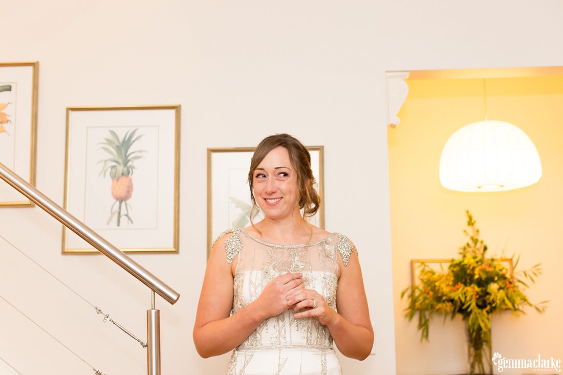 A smiling bride standing on stairs