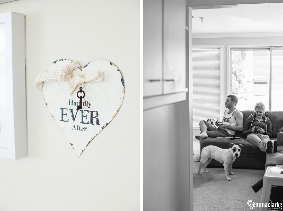 A bride and groom relaxing on a couch with their dog before their wedding, and a love heart shaped sign that says "Happily ever after"