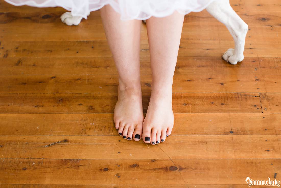 A bride's feet with black nail polish