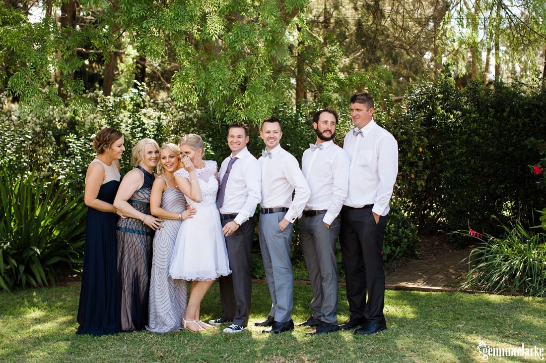 A bride and groom posing with their wedding party