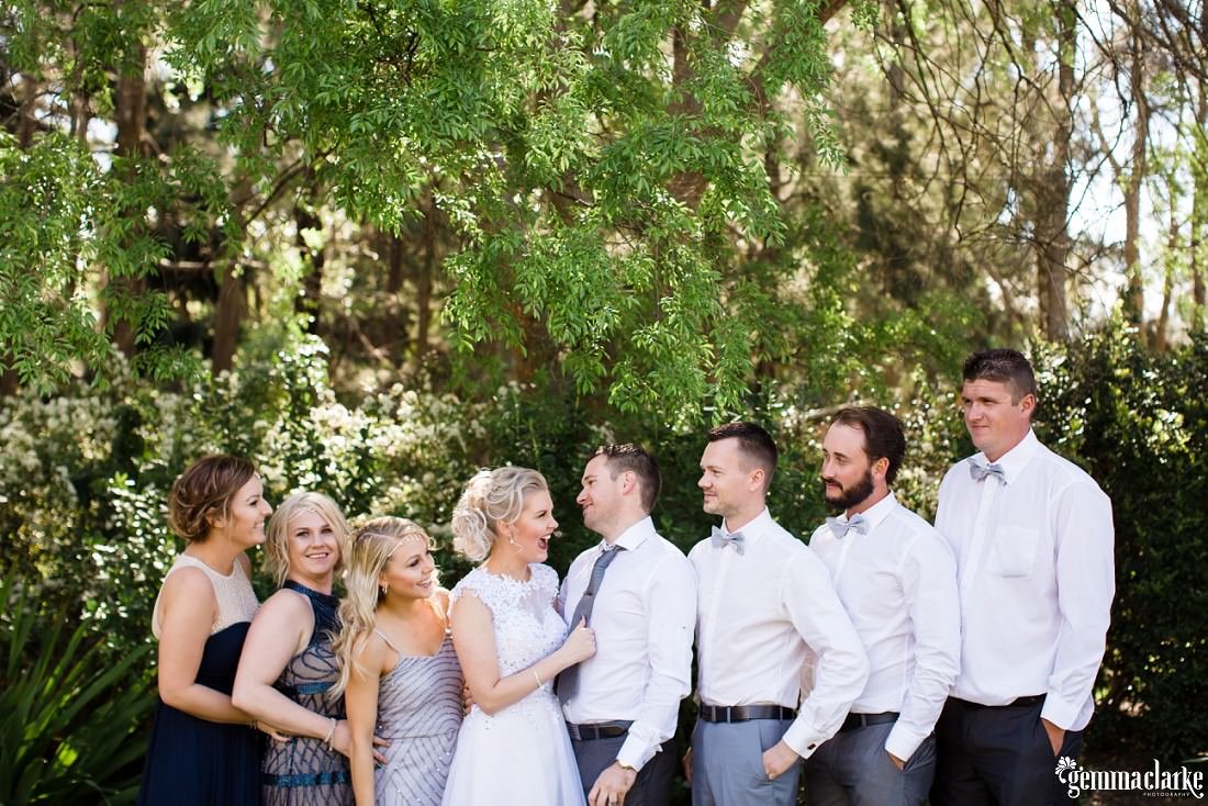 A bridal party posing together and looking at each other