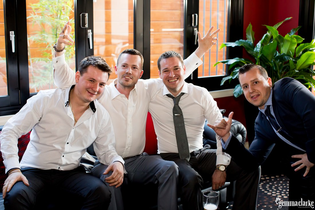 A groom posing with friends on a couch