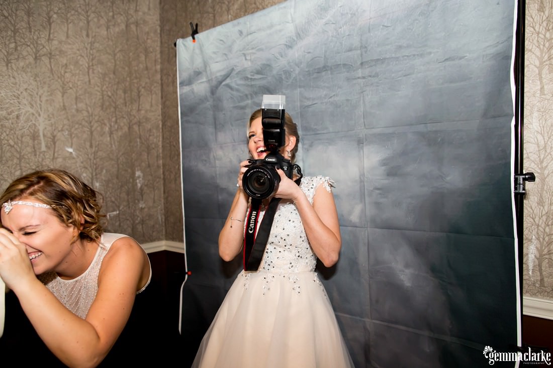 A smiling bride holding a camera