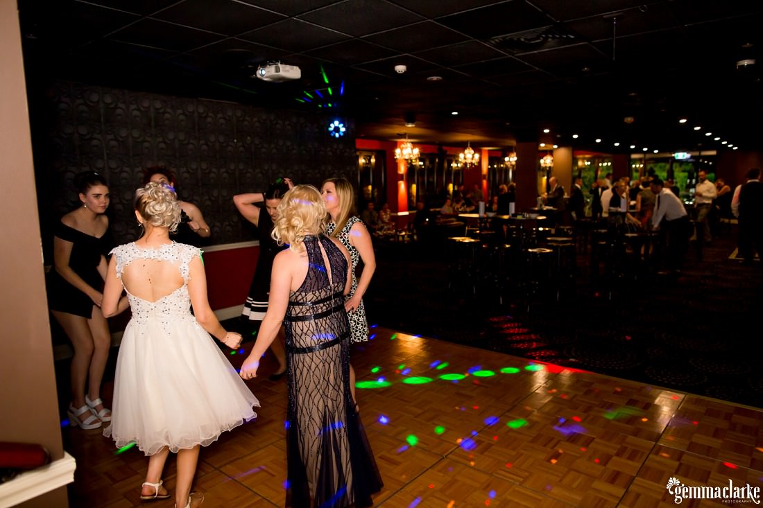 A bride and some of her guests busting moves on the dance floor