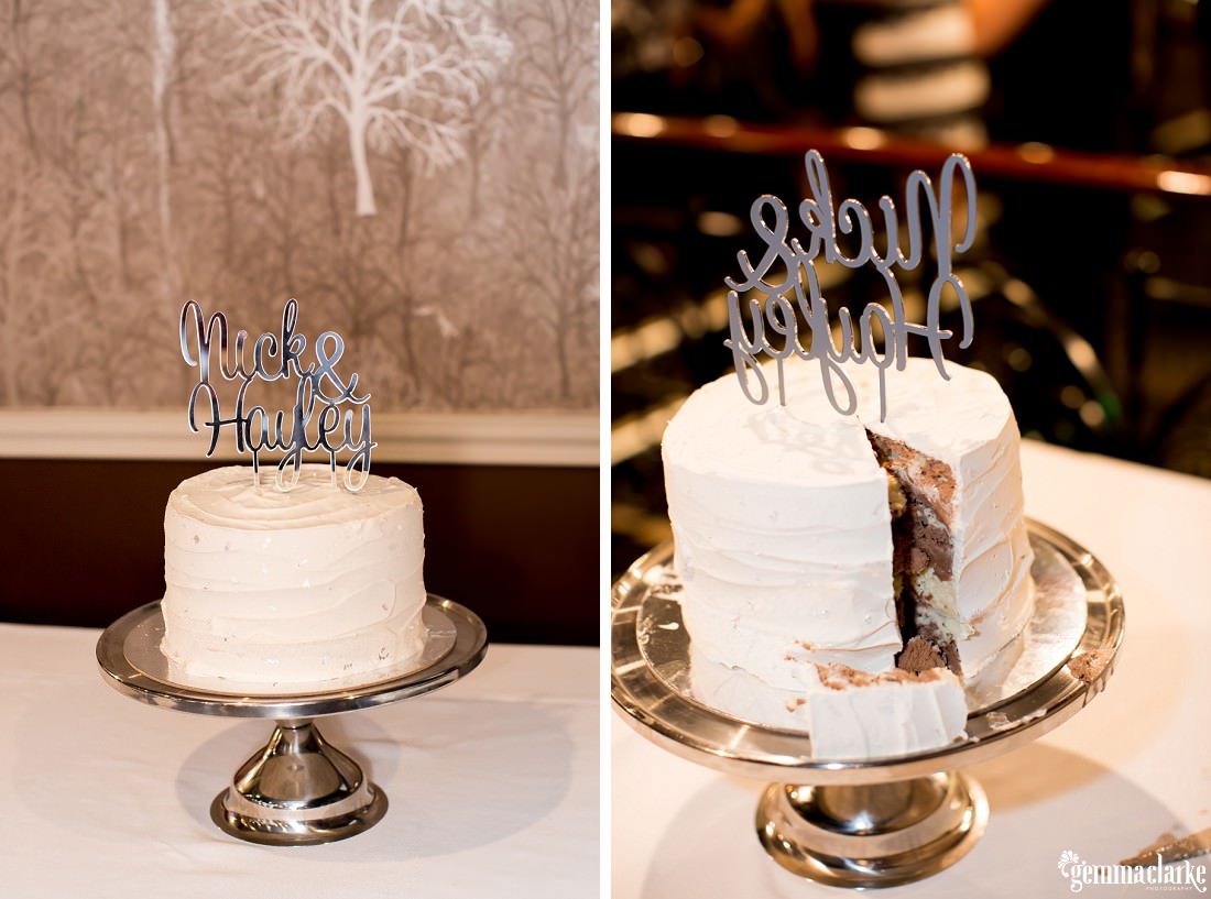 A white wedding cake with a topper with the bride and groom's names and a slice cut out