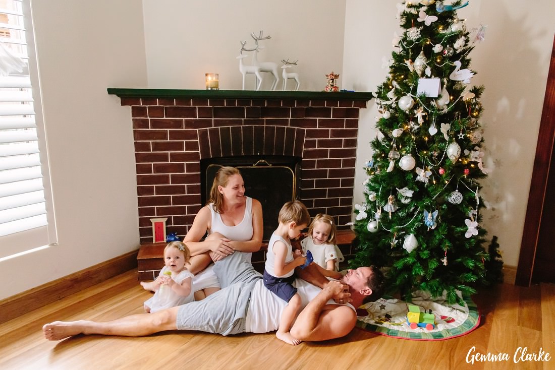Relaxed Family portrait in front of the Christmas tree. Not posed, just having fun together at this Christmas Shoot.