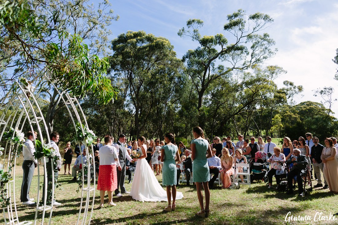 Beautiful ceremony setup with arches in the bush with guests looking on at this Belair Park Wedding