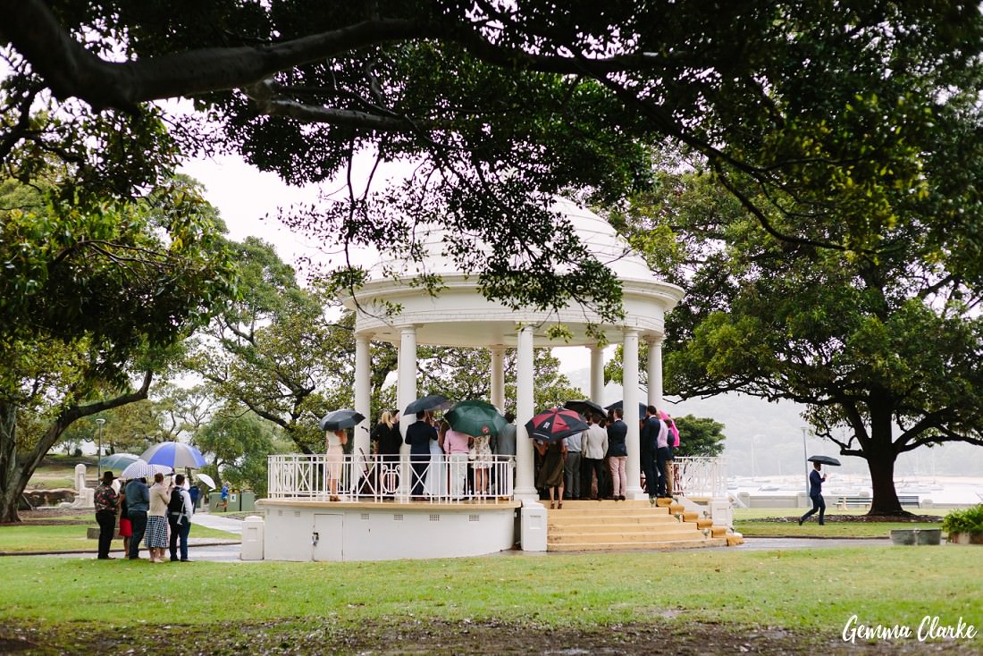 Balmoral Beach Rotunda wedding ceremony with many umbrellas at this Sydney rainy day wedding