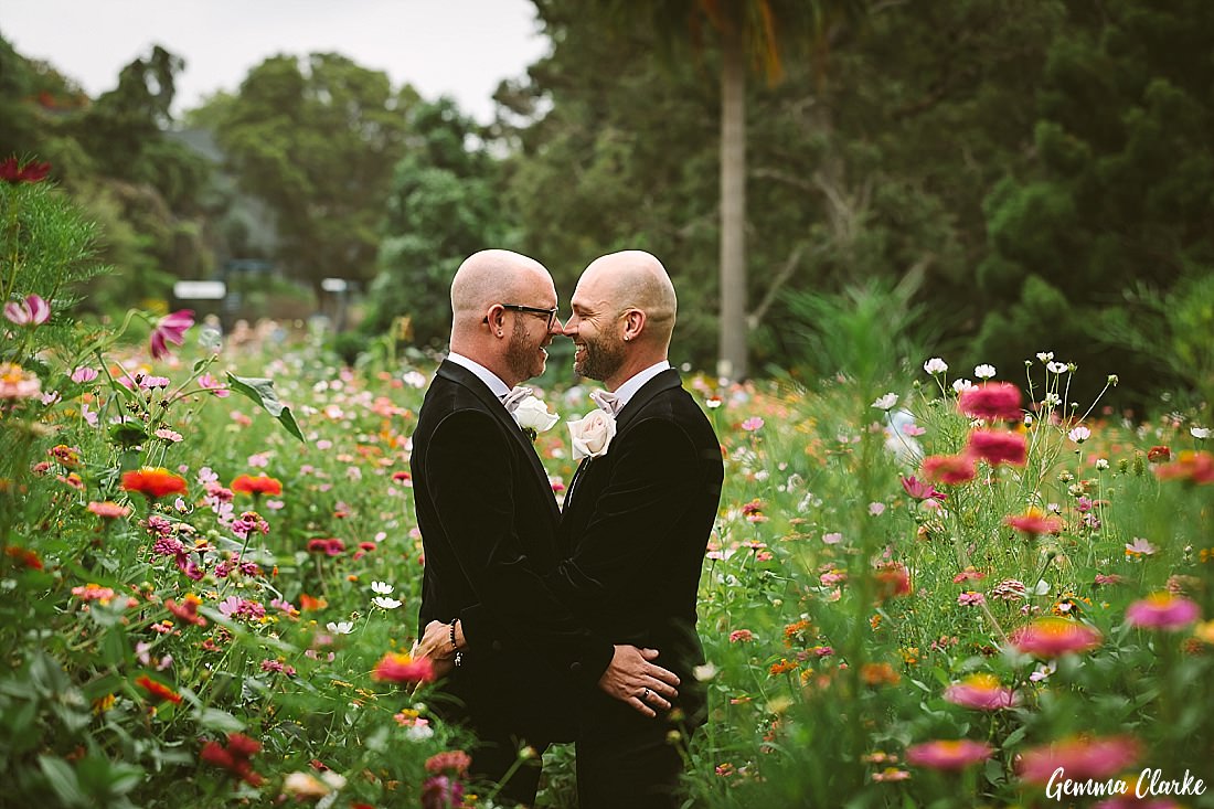 Cuddles in the wildflower garden for these two newly married grooms at this Sydney Gay Wedding