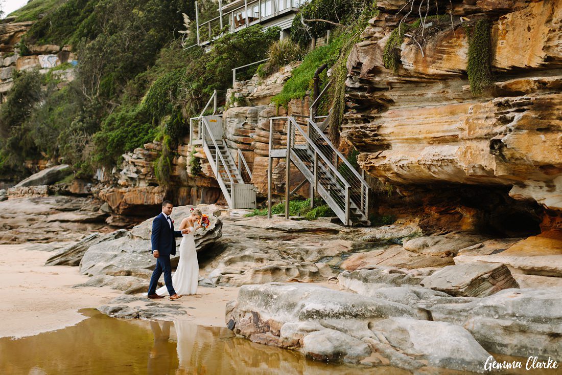Beautiful rock formations as the bride and groom walk alongside the water at their Freshwater Wedding