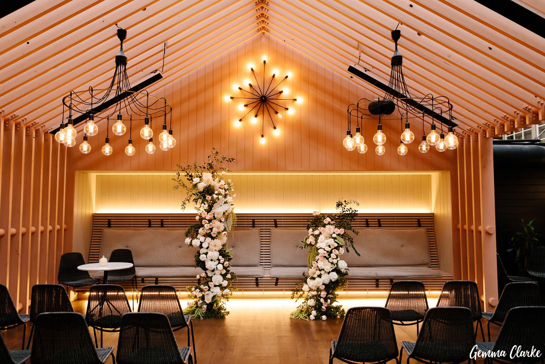 Unique ceremony venue with retro lights and florals at this Ovolo Hotel Wedding