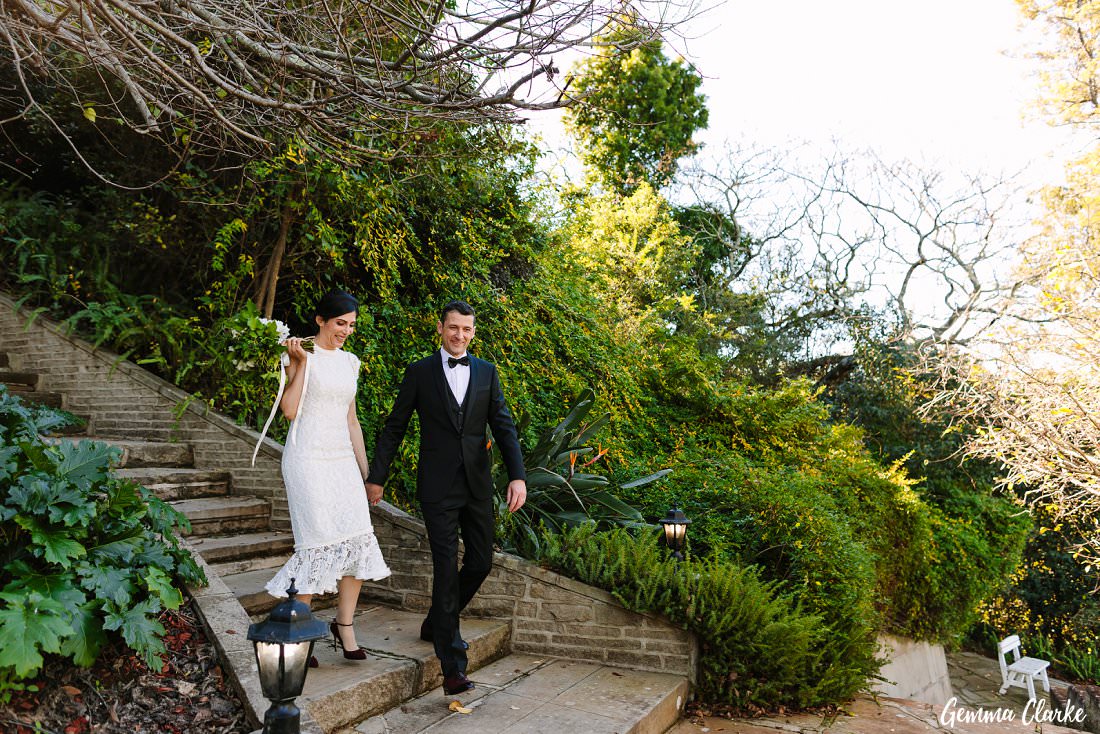 The bride and groom walk down the beautiful stairs with big grins at their Loxley on Bellbird Hill Wedding